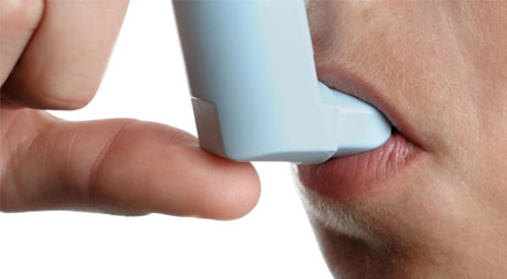 A man is using an electronic device to check his mouth.